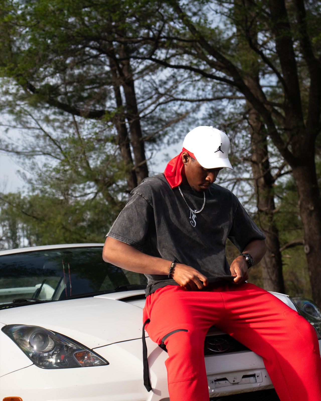 Model in New Stage tee sitting on a Celica hood
